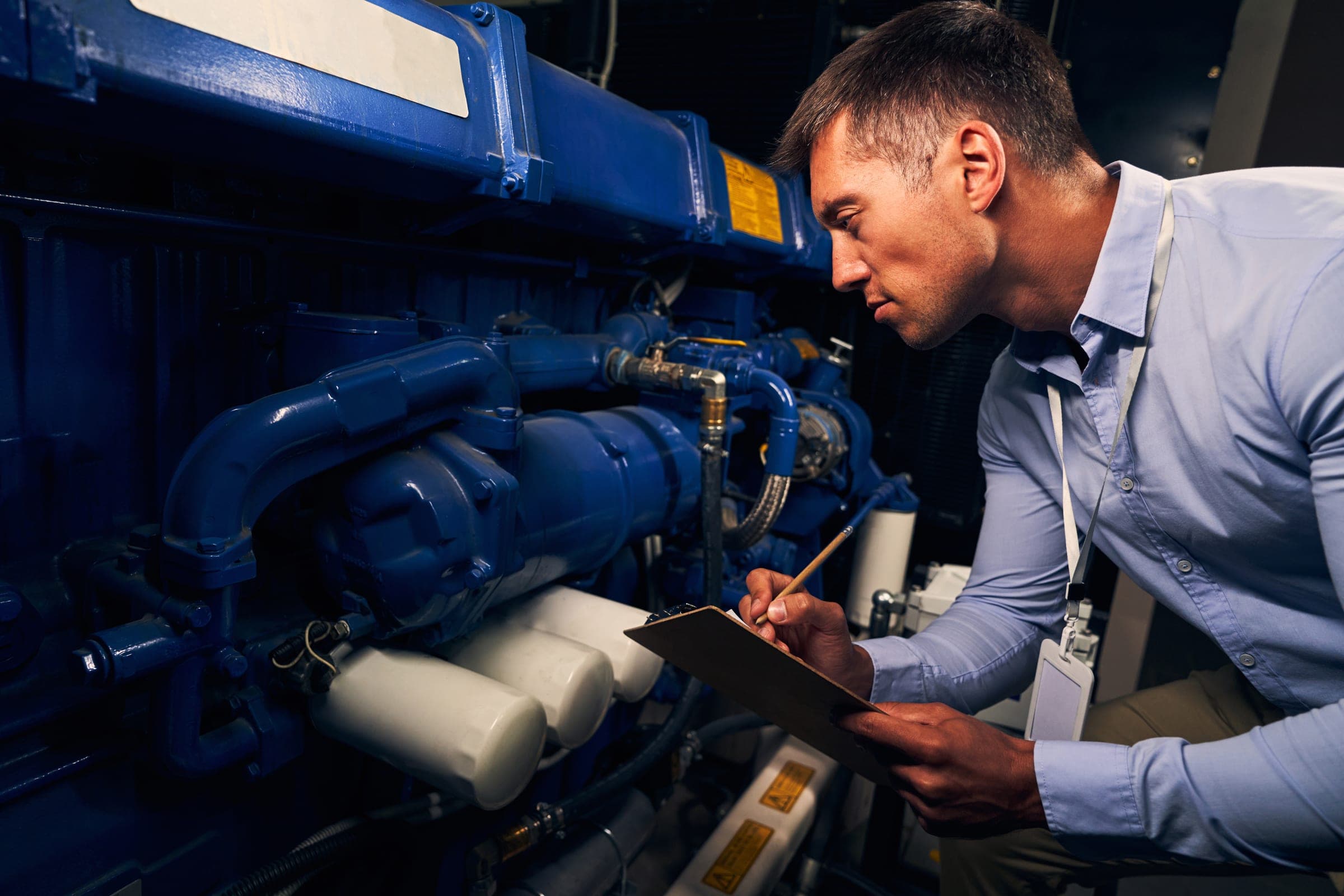 Auditor inspecting machinery in an engine room